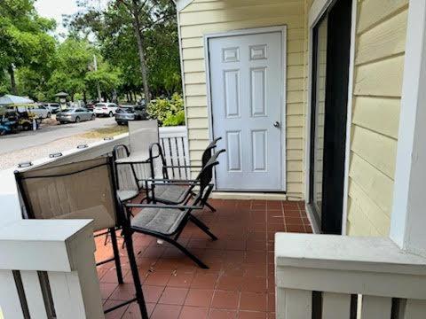 un porche con 2 sillas y una puerta en una casa en Sealoft 4 Townhouse, en Myrtle Beach