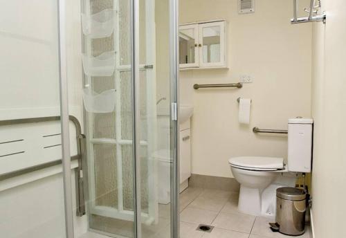 a bathroom with a toilet and a glass shower at ANCHORAGE in Amity Point