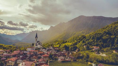 una pequeña ciudad en las montañas con una iglesia en Hiša Nataša, en Drežnica