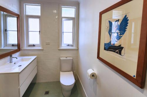 シドニーにあるDiscover Queenscliffのバスルーム(トイレ付)が備わります。壁に絵画が飾られています。