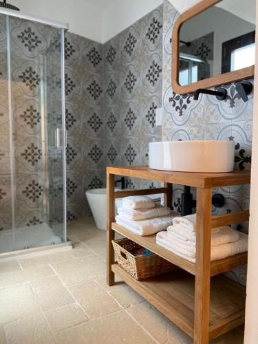 a bathroom with a sink and a shower with towels at Nonna Cia in Gallipoli