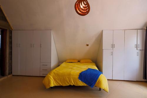 1 dormitorio con 1 cama con manta amarilla y azul en Amboseli Cultural Camping en Amboseli
