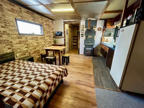 Kamennaya GoraにあるScandinavia bungalowのベッド1台付きの部屋、テーブル付きのキッチンが備わる客室です。