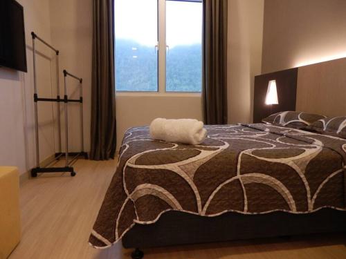 una camera da letto con un grande letto con una grande finestra di Windmill Upon Hills, Genting Highlands 2 King bed & 2 free car park a Resorts World Genting