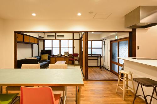 Third&Place Kyoto_ShijoOmiya/四条大宮 في كيوتو: مطبخ وغرفة معيشة مع طاولة وكراسي