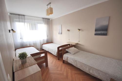 a small room with two beds and a table at Apartamenti Jēkabpilī in Jēkabpils