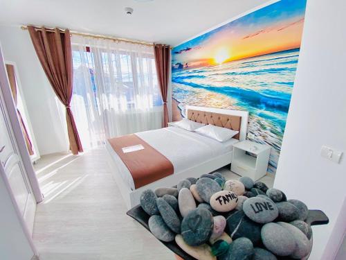 a bedroom with a bed and a painting of the ocean at IANIS Rooms in Mangalia