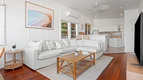 a living room with a white couch and a table at SunDayz in Yamba