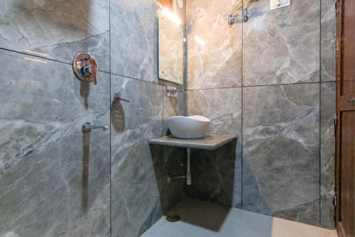 a bathroom with a glass shower with a sink at MHA hotels MOORANG mall manali in Manāli