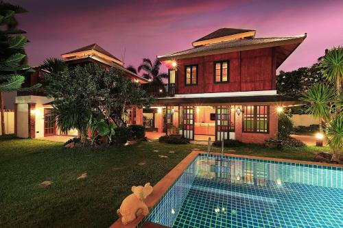 a house with a swimming pool in front of a house at WoLin Lemon Resort in Ban Saiyuan (1)