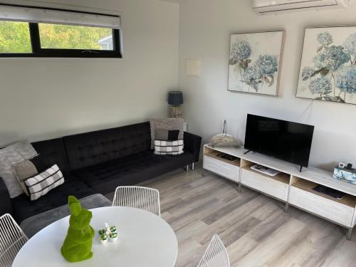 a living room with a couch and a tv at Farm Stay POPLAR Cottage at Wilindi Estate in Tyabb