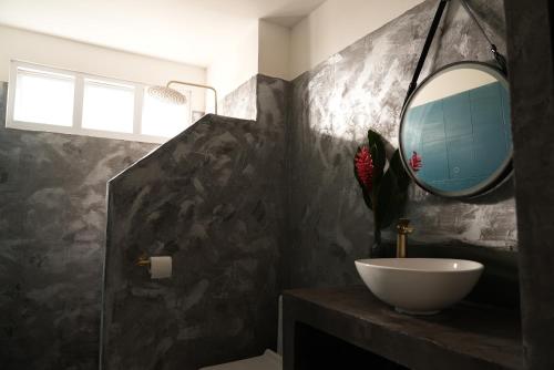 baño con lavabo y espejo en la pared en Papeete appartement entier à 10 min de L'aéroport, en Papeete