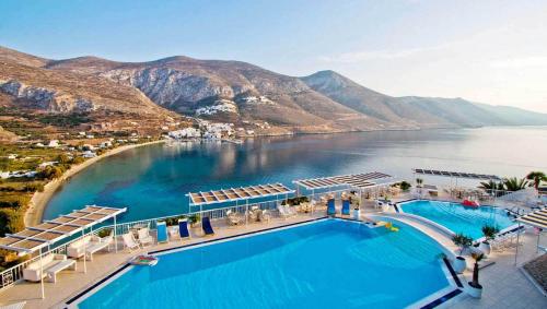 una vista aerea su una piscina del resort con montagne sullo sfondo di Aegialis Hotel & Spa ad Aegiali