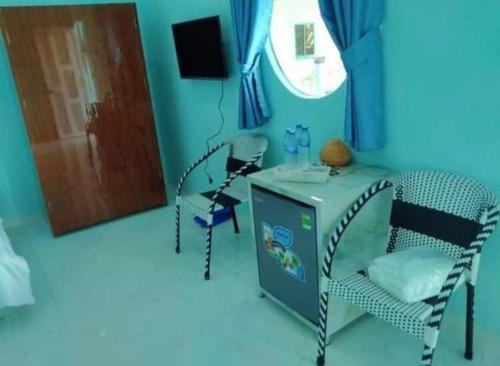 a blue room with chairs and a table and a door at Phuoc Long Homestay in Ha Tien
