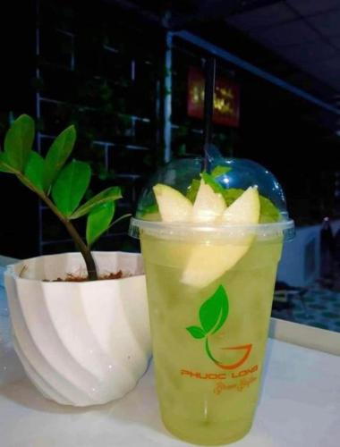 a drink in a plastic cup next to a potted plant at Phuoc Long Homestay in Ha Tien
