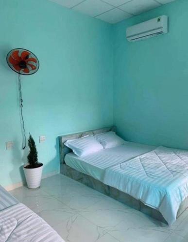 a blue bedroom with a bed and a fan at Phuoc Long Homestay in Ha Tien