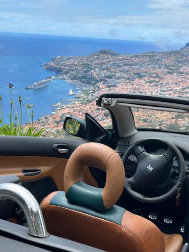 a car with a steering wheel and a view of the ocean at Apartamentos do Mar Funchal in Funchal