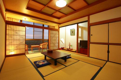 a living room with a table and a television at Yumoto Kobayashi in Kurume