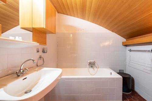 a bathroom with a sink and a bath tub at [LAGO DI CAREZZA] Dolomiti Vista Mozzafiato in Nova Levante