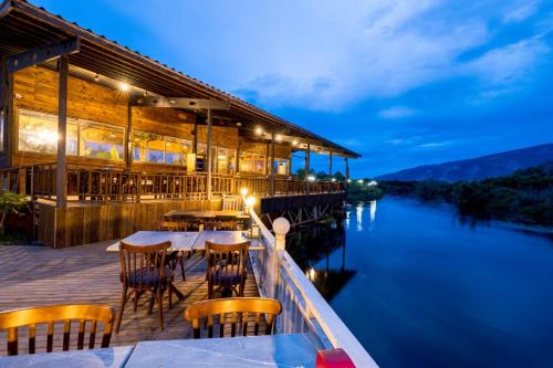 a restaurant with tables and chairs next to the water at TurkuazKöy in Finike