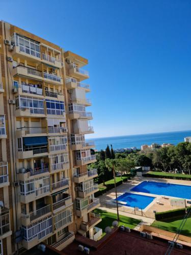 een groot appartementencomplex met een zwembad en de oceaan bij Hércules Benalmádena in Benalmádena