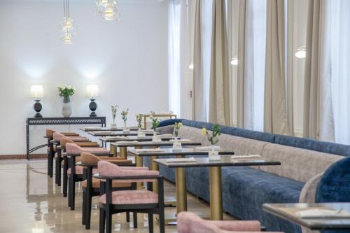 a long line of tables and chairs in a room at LOTTE City Hotels Tashkent Palace in Tashkent