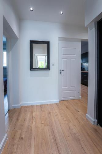 an empty room with a white wall and a door at Oliwa Am Calsberg 5a in Gdańsk