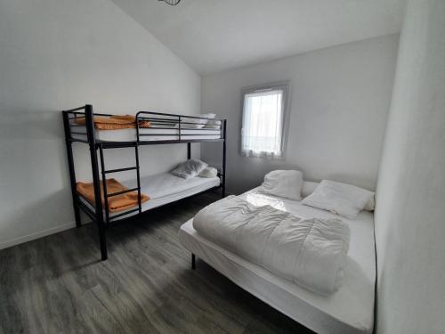 une chambre avec deux lits superposés et une fenêtre dans l'établissement Maisonnette conviviale proche plage pour 4 pers. - FR-1-476-174, à La Faute-sur-Mer