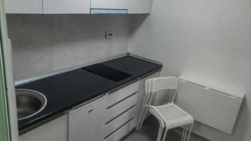 eine Küche mit einer Spüle und einem Stuhl darin in der Unterkunft Cholakovi Apartments in Veles