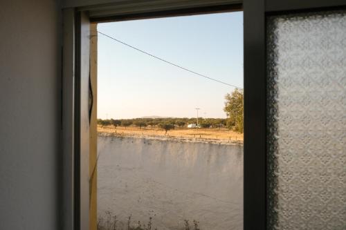Além Tejo Guesthouse في ميرتولا: نافذة مطلة على جسم ماء