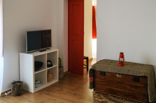 A television and/or entertainment centre at Além Tejo Guesthouse