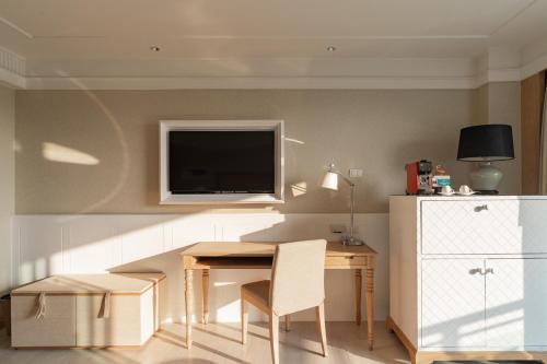 a living room with a table and a tv on the wall at Amari Hua Hin in Hua Hin