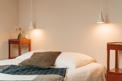 a bedroom with a bed with a blanket and two lights at le chalet de Plainpalais in Les Déserts