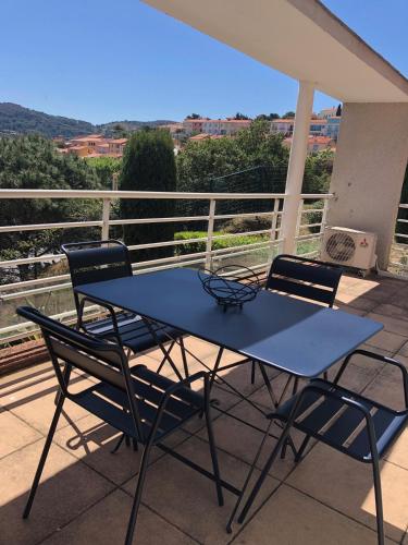 d'une table bleue et de deux chaises sur un balcon. dans l'établissement La Terrasse, à Port-Vendres