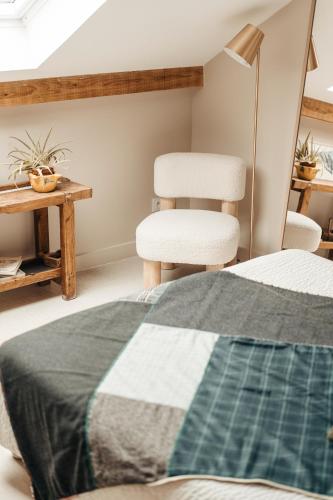 a bedroom with a bed and two chairs and a table at le chalet de Plainpalais in Les Déserts