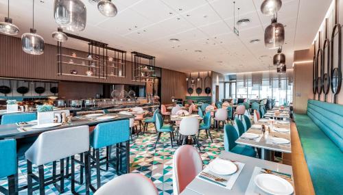 a dining room with tables and chairs at Mustel Hotel Knowledge City Guangzhou in Guangzhou