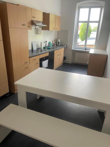 シュタースフルトにあるTränental 4.5の白いテーブル付きのキッチンが備わる客室です。