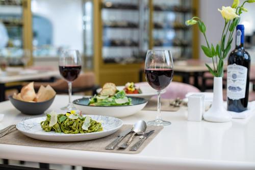 a table with two glasses of wine and plates of food at LOTTE City Hotels Tashkent Palace in Tashkent
