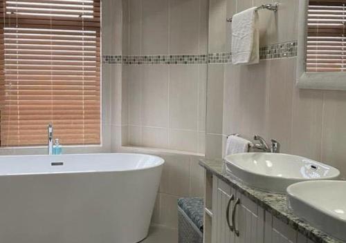 a bathroom with a tub and a sink and a bath tub at Moon Landscape Self Catering in Swakopmund