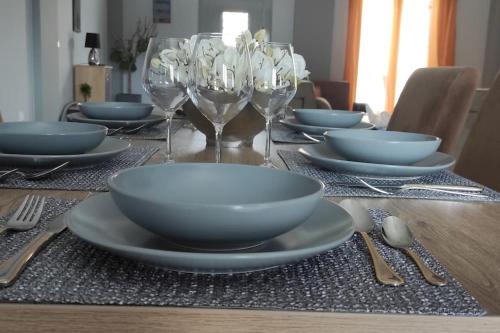 a table with plates and wine glasses on it at Anastasia&Filippos house in Ágios Matthaíos