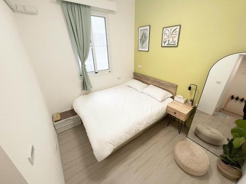 a small bedroom with a white bed and a window at Good Stay in Tainan
