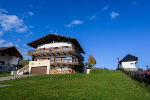 a house on top of a grassy hill at Chalet First Hill in Gura Humorului