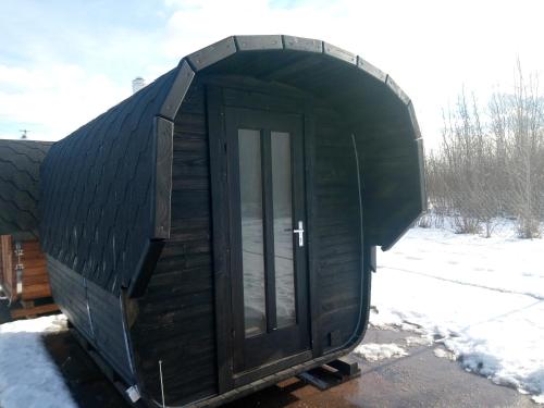 a black cabin with a door in the snow at Marija in Krāslava
