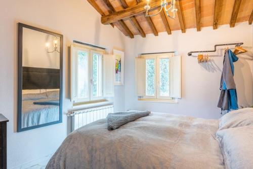 a bedroom with a large bed and two windows at The Liberties - Luxury Villa in Barga Old Town in Barga