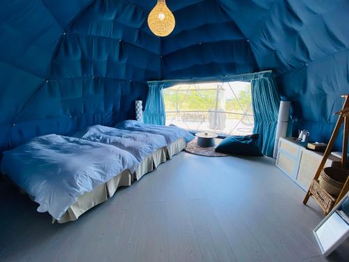 a blue room with two beds and a window at chillout glamping zao in Zao