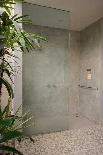 a shower with a glass door in a bathroom at The Bed by The Sea in Canggu