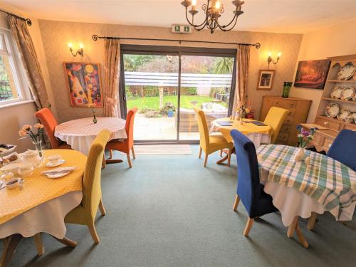 a dining room with tables and chairs and a window at Foxhills of Shanklin in Shanklin