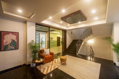 a living room with a staircase and a chair at Olive Electronic City - by Embassy Group in Bangalore
