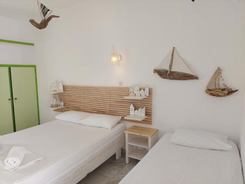 two beds in a room with white walls at Brunis Apartments in Nei Poroi