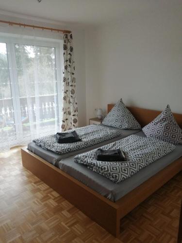 una cama en una habitación con una ventana grande en Wohnung Gretl, en Bayerisch Eisenstein